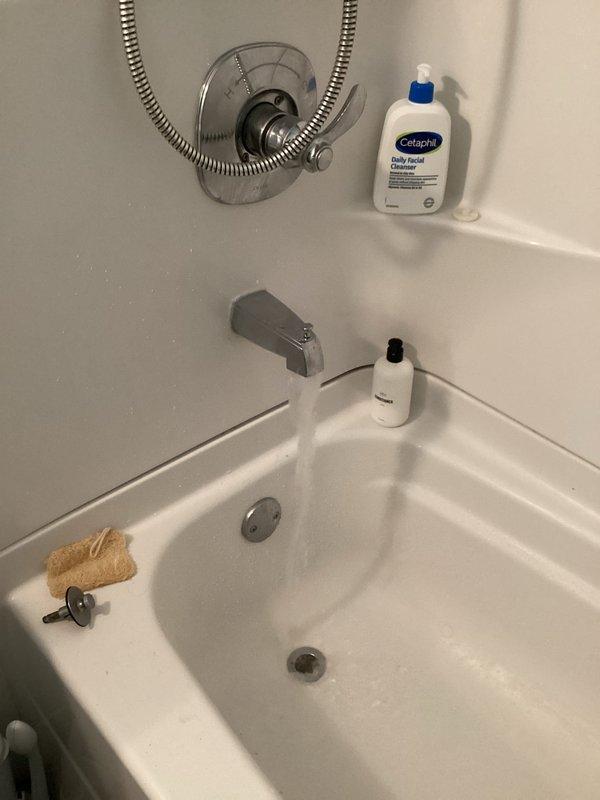 Responded to water leak complaint affecting basement area during shower operation. Inspected tub/shower assembly and identified leak source at shower valve trim and handle set rather than tub drain as initially suspected. Tightened valve stem packing nuts, replaced worn valve cartridge seals, and resealed escutcheon plate against wall surface to eliminate water intrusion. Tested system by running shower at full pressure to verify leak was resolved and no water penetration occurred into basement below.