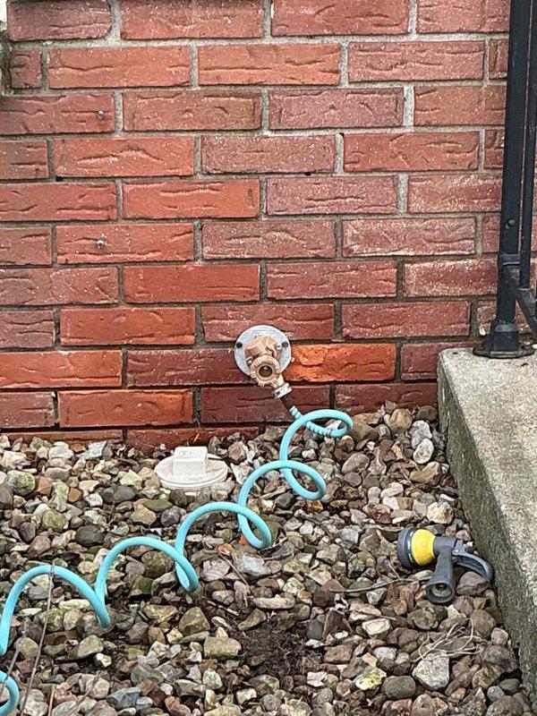 Completed comprehensive water service repipe for residential property, replacing outdated plumbing infrastructure with modern PEX piping system. Interior installation included mounting washing machine outlet box with hot and cold water valves, installing brass manifold assembly, and routing color-coded PEX lines (red for hot, blue for cold) throughout the wall cavity with proper support strapping and connections using braided stainless steel supply lines. Exterior work involved installing new hose bib on brick wall foundation to provide outdoor water access. All connections were secured, tested for leaks, and verified for proper water flow and pressure throughout the system.