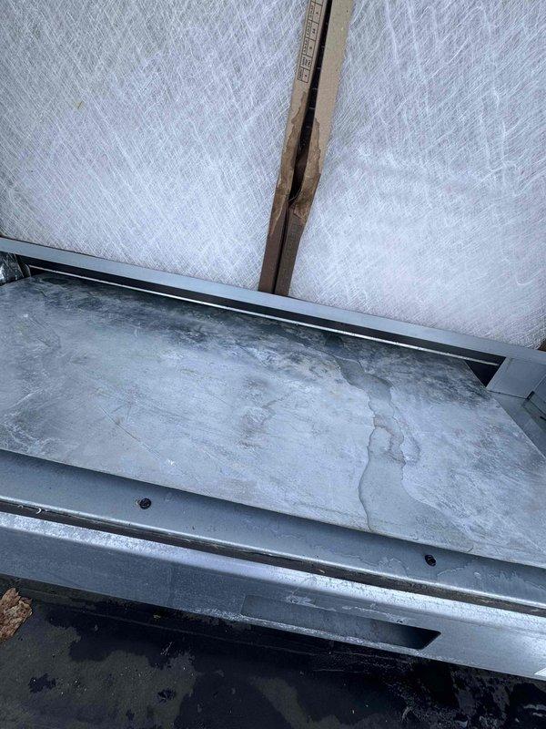 Responded to emergency call for complete loss of cooling and active water infiltration through ceiling tiles in multiple customer areas, including front counter and menu board locations. Investigated rooftop unit and identified compromised condensate drain system causing overflow and water penetration into occupied space near electrical components. Cleared drain line obstruction, verified proper drainage flow, inspected roof curb flashing and insulation integrity at unit penetration, and confirmed system returned to normal cooling operation with no further water leakage.