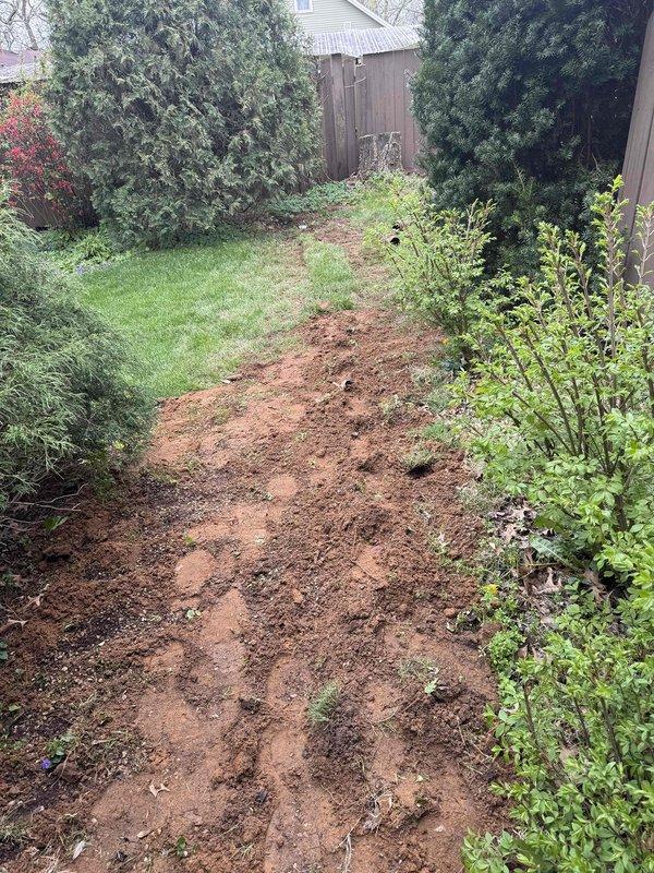 Excavated and installed new drainage piping system for sump pump discharge and downspout routing in residential backyard. Trenched pathway through lawn area to accommodate underground PVC drainage lines, ensuring proper grade and slope for water flow away from foundation. Installed PVC piping configuration with trap assembly along building exterior, connecting sump pump outlet and downspout drainage to new underground system. Completed plumbing maintenance inspection of existing utility connections and verified proper operation of all drainage components.