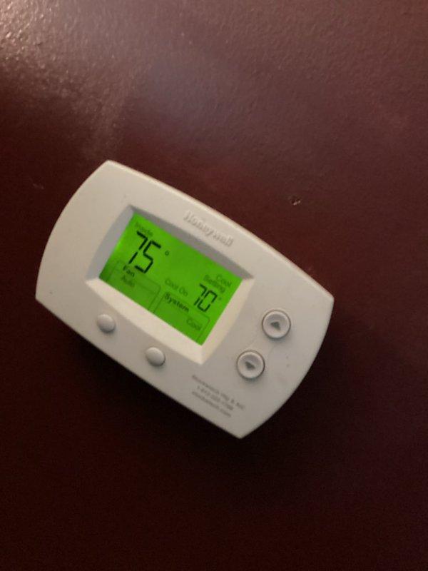 Responded to no cooling call for residential air conditioning system over 10 years old. Upon arrival, found outdoor condenser unit installed on ground level against brick exterior wall. Performed system diagnostics and temperature differential testing at thermostat, which displayed current temperature of 75°F with setpoint at 70°F, indicating unit was not maintaining desired cooling temperature. Conducted comprehensive inspection of condenser unit including visual assessment of compressor operation, refrigerant levels, and electrical components. Evaluated airflow through louvers and checked for proper condenser fan operation. System restored to normal cooling operation following service procedures.