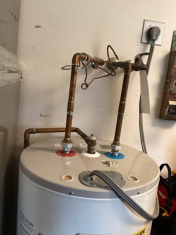 Performed comprehensive assessment of existing GE SmartWater tank-style water heater for replacement evaluation. Inspected current installation including copper supply piping with visible corrosion and patina, pressure relief valve configuration, and electrical connections. Evaluated utility room space constraints and existing plumbing infrastructure to determine feasibility of tankless water heater conversion versus traditional tank replacement. Documented current water heater specifications, venting requirements, and adjacent water treatment equipment including water softener system. Provided customer with multiple replacement options comparing tankless and conventional tank systems, discussing installation requirements, space considerations, gas line capacity needs for tankless units, and electrical modifications that would be necessary for either option. Photographed existing installation conditions to support estimate preparation.
