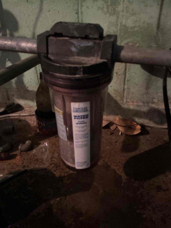 Completed comprehensive whole home plumbing inspection per customer request. Evaluated existing water filtration system installed in basement utility area, which included a clear housing unit with translucent cylinder connected to copper supply lines. Inspected and replaced water filter cartridge, removing heavily soiled dark brown/black filter element and installing new light blue replacement cartridge with textured surface and white end caps. Discussed water quality improvement options with customer regarding additional filtration equipment installation for future consideration.