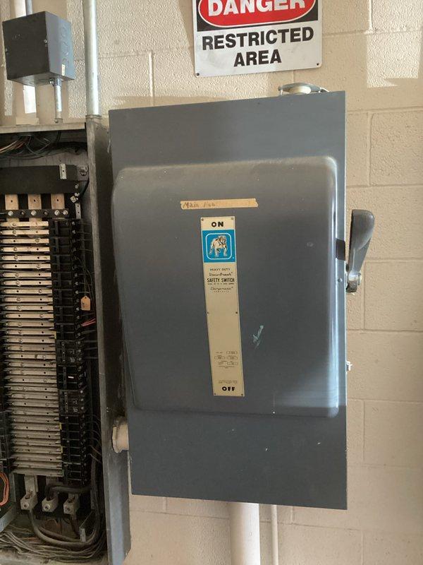 Responded to no cooling call on central air conditioning system approximately 10-15 years old. Upon arrival, located air handling unit mounted at ceiling level in multi-level commercial space. Performed diagnostic evaluation of system components and verified electrical disconnect switch position on concrete block wall near equipment panel. Inspected circuit breaker panel and electrical connections serving HVAC system. Documented equipment conditions and electrical infrastructure with photos for service records. System evaluated and findings reviewed with occupant.