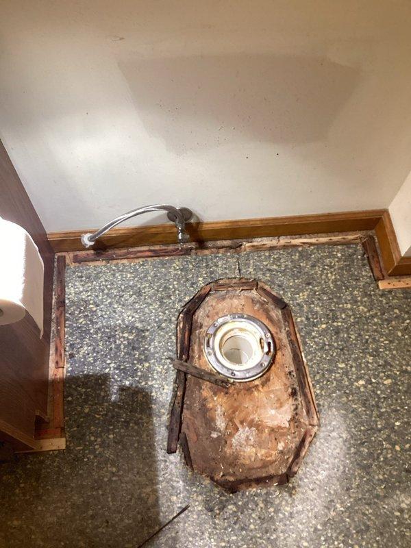 Returned to address additional toilet repairs identified during previous service call where obsolete metal supply lines were replaced. Coordinated entry access with flooring contractors on site. Inspected bathroom fixtures and documented conditions including toilet installation with recently installed braided stainless steel supply line and shutoff valve. Observed secondary bathroom shower stall exhibiting severe deterioration of drain assembly with extensive rust corrosion on metal components and water damage to surrounding composite flooring and wooden trim. Completed photographic documentation of fixture conditions for service records.