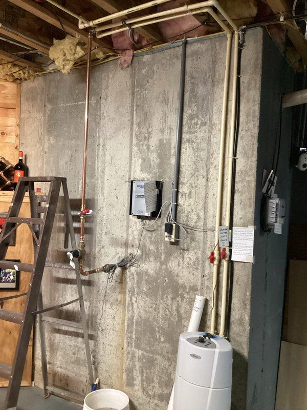 Completed full repipe of incoming water lines in basement utility area. Removed existing deteriorated piping and installed new copper supply lines along concrete foundation wall, including proper valve connections, fittings, and pressure regulation components. Secured all new copper piping with appropriate mounting hardware to concrete and wooden structural members. Integrated electrical conduit routing alongside plumbing installation to maintain organized utility pathways. All connections were properly soldered, tested for leaks, and verified for adequate water pressure and flow throughout the system.