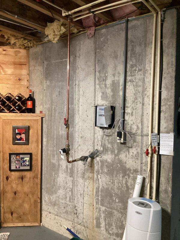 Completed full repipe of incoming water lines in basement utility area. Removed existing deteriorated piping and installed new copper supply lines along concrete foundation wall, including proper valve connections, fittings, and pressure regulation components. Secured all new copper piping with appropriate mounting hardware to concrete and wooden structural members. Integrated electrical conduit routing alongside plumbing installation to maintain organized utility pathways. All connections were properly soldered, tested for leaks, and verified for adequate water pressure and flow throughout the system.