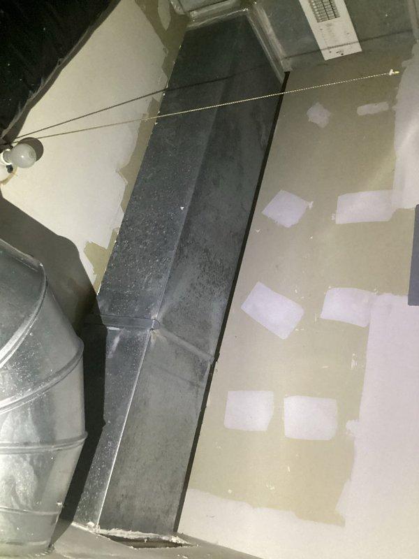 Responded to follow-up service call for recurring ductwork leak issue previously identified during routine maintenance. Conducted thorough inspection of attic-installed supply plenum and duct transitions, documenting current conditions with photos showing aged metal ductwork with visible surface deterioration and compromised sealing at connection points. Assessed wall-mounted vent register installation in mechanical space where water intrusion damage was evident from peeling paint and wall surface deterioration around ductwork penetrations, indicating ongoing condensation or leak concerns requiring remediation.