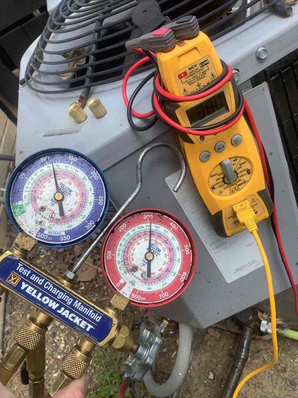 Responded to diagnostic service call for HVAC system malfunction. Performed comprehensive system diagnostics using multimeter for electrical testing and Yellow Jacket manifold gauge set to check refrigerant pressures on dual outdoor condenser units. Units showed visible signs of age with weathering, oxidation, and rust-colored staining on components and fan grilles. Evaluated electrical components, refrigerant levels, and overall system operation to identify root cause of reported issue.
