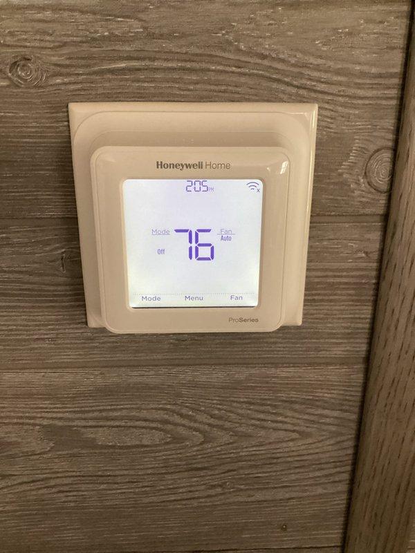 Responded to no cooling complaint on residential Guardian brand split system air conditioning unit. Upon arrival, performed visual inspection of outdoor condensing unit and indoor thermostat controls. Honeywell Home ProSeries thermostat displayed 76°F with system in off mode and fan set to auto operation, with WiFi connectivity active. Conducted diagnostic evaluation of condenser unit positioned on concrete pad, noting unit appeared operational with fan assembly visible and accessible. Verified electrical connections, refrigerant lines, and condensate drainage pathways. System components showed no obvious signs of mechanical failure or damage to housing, grille, or external connections.