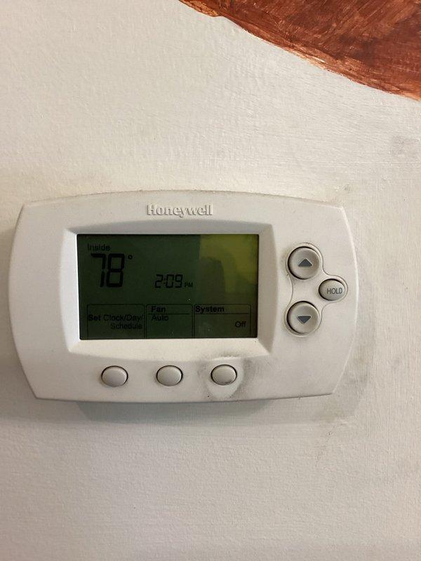 Responded to no cooling complaint on residential air conditioning system. Upon arrival, found Honeywell thermostat set to system off position with display showing 78°F and 2:08 PM. Diagnosed faulty thermostat preventing system operation. Removed existing Honeywell unit and installed new Tru-Temp programmable thermostat. Verified proper wiring connections and configured new thermostat settings. System now operational with accurate temperature control restored.