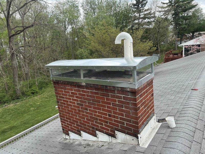 Installed metal chimney cap with mesh screening on brick chimney structure to prevent animal and debris intrusion while maintaining proper ventilation. Inspected heat pump and furnace system for reported leak concerns and documented equipment condition. All work completed per manufacturer specifications with system operational upon departure.