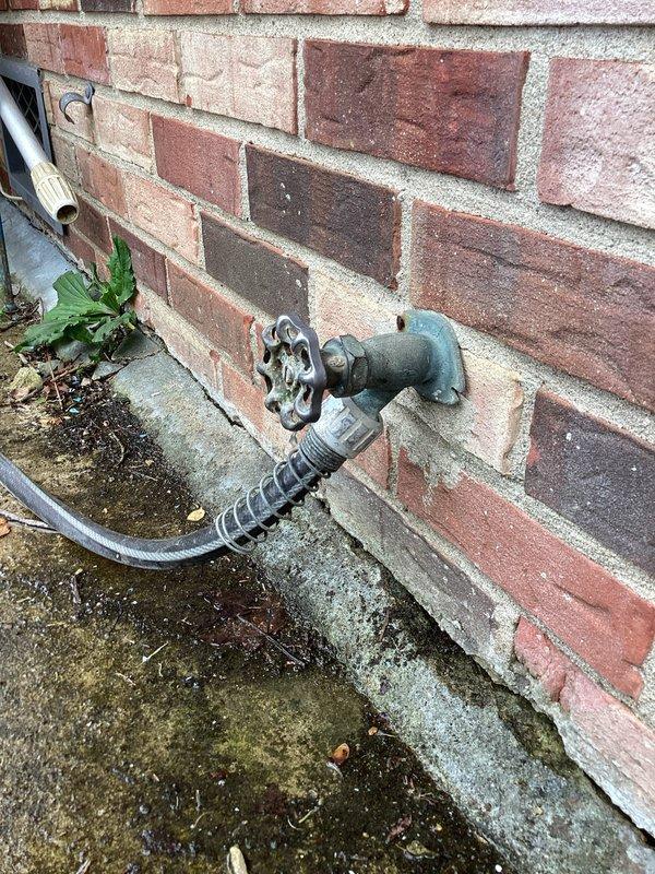 Completed plumbing estimate for capping off a gas line to the fireplace and replacing an exterior hose spigot mounted on brick wall. The existing outdoor spigot showed weathering and age-related deterioration with visible patina on the metal fixture. Assessment included evaluation of the wall-mounted installation, foundation area conditions, and accessibility for replacement work.