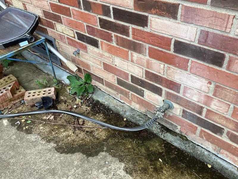 Completed plumbing estimate for capping off a gas line to the fireplace and replacing an exterior hose spigot mounted on brick wall. The existing outdoor spigot showed weathering and age-related deterioration with visible patina on the metal fixture. Assessment included evaluation of the wall-mounted installation, foundation area conditions, and accessibility for replacement work.