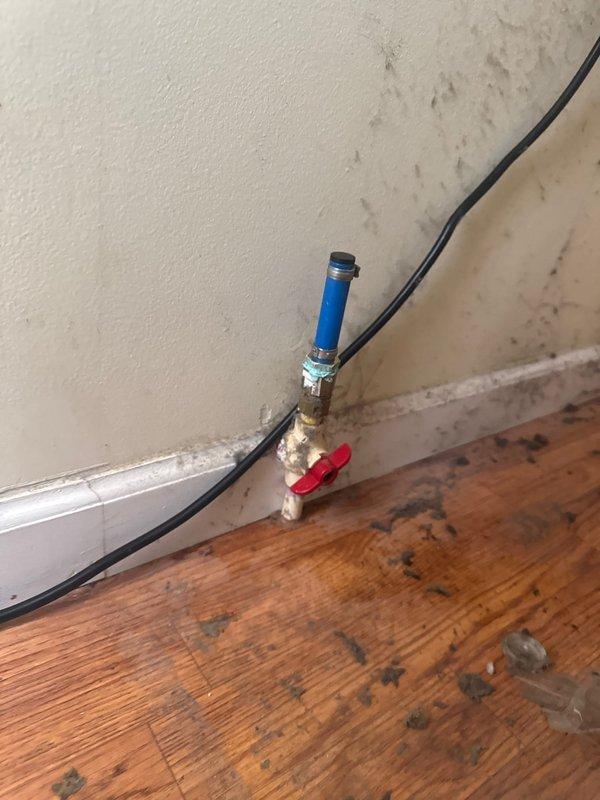 Responded to a request to disconnect and cap a refrigerator water supply line. Upon arrival, located the existing blue PEX water line with brass ball valve and red handle at the wall-floor junction. Disconnected the refrigerator supply line, properly capped the water line to prevent leaks, and verified the shutoff valve was functioning correctly. Documented the installation with photos showing the capped line and removed flexible braided supply hose.