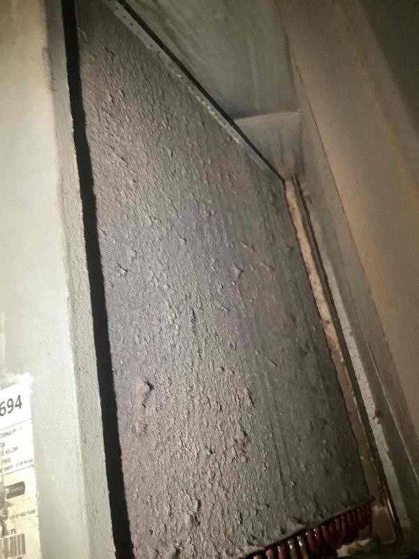 Performed air conditioning system inspection and maintenance. Inspected air filtration system and found filter heavily loaded with dust and debris accumulation, reducing airflow efficiency. Examined HVAC control board assembly and documented condition of dual circuit board configuration with multiple wire terminations. Noted visible corrosion and discoloration on circuit boards around connection points and component areas, indicating age-related wear and environmental exposure. System operational at time of inspection.