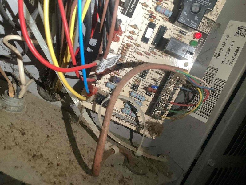 Performed air conditioning system inspection and maintenance. Inspected air filtration system and found filter heavily loaded with dust and debris accumulation, reducing airflow efficiency. Examined HVAC control board assembly and documented condition of dual circuit board configuration with multiple wire terminations. Noted visible corrosion and discoloration on circuit boards around connection points and component areas, indicating age-related wear and environmental exposure. System operational at time of inspection.