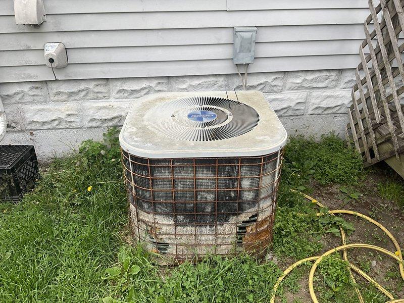 Completed comprehensive estimate for full HVAC system replacement including aging outdoor condenser unit with weathered protective cage and deteriorating basement furnace with corroded copper piping. Documented existing equipment condition through detailed photography, noting significant wear on exterior condenser components and oxidation on furnace connections, and presented available replacement options with current promotional offers including extended labor warranty coverage.