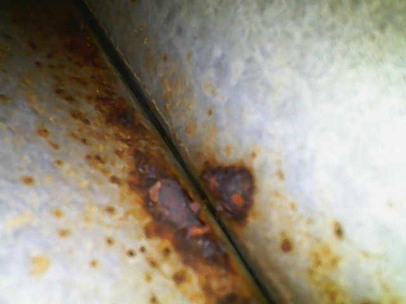 Responded to no-cooling call for residential air conditioning system. Upon arrival, confirmed outdoor condensing unit was not operating while indoor air handler and blower motor functioned normally. Conducted visual inspection of outdoor unit and discovered extensive rust corrosion on refrigerant line set and condensing unit cabinet panels, indicating prolonged moisture exposure and potential refrigerant leak points. Documented deteriorated condition of copper refrigerant lines showing significant oxidation and corrosion patterns. Advised homeowner of equipment condition and recommended comprehensive system evaluation to determine extent of refrigerant line damage and assess condenser unit integrity before proceeding with repairs.