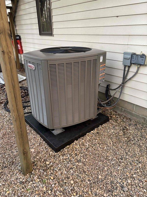 Completed full HVAC system installation featuring a Lennox heat pump with matching indoor coil and integrated humidifier. The outdoor heat pump unit was positioned on a composite pad with gravel base against the exterior wall, with electrical disconnect and line set connections properly installed and secured. Inside, the air handler was mounted with complete ductwork integration, humidifier installation for whole-home comfort control, and all electrical connections completed to code. System was tested, charged to manufacturer specifications, and verified operational in both heating and cooling modes.
