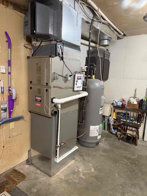 Completed full HVAC system installation featuring a Lennox heat pump with matching indoor coil and integrated humidifier. The outdoor heat pump unit was positioned on a composite pad with gravel base against the exterior wall, with electrical disconnect and line set connections properly installed and secured. Inside, the air handler was mounted with complete ductwork integration, humidifier installation for whole-home comfort control, and all electrical connections completed to code. System was tested, charged to manufacturer specifications, and verified operational in both heating and cooling modes.