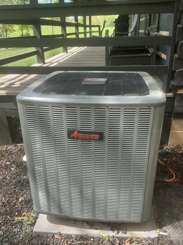 Completed basic monthly heating maintenance on Amana heat pump system. Performed standard inspection of outdoor unit located beneath deck structure, verified refrigerant lines and connections, and checked Honeywell programmable thermostat operation inside residence. System operating within normal parameters at time of service.