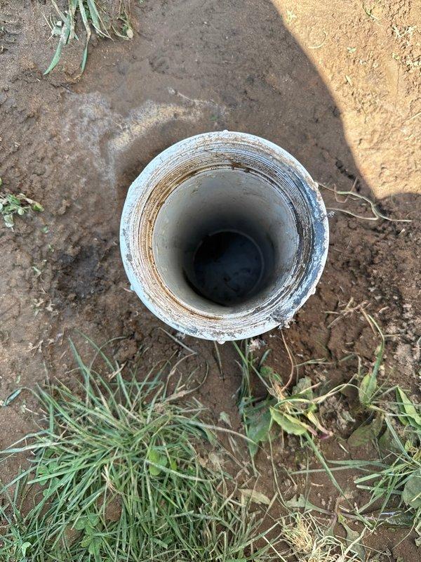 Responded to residential sewer line backup and pipe blockage complaint. Located and accessed exterior ground-level PVC cleanout, which showed visible interior staining and residue buildup indicating active drainage issues. Performed main drain cleanout procedure to clear blockage and restore proper flow through the sewer line, verifying system functionality upon completion.