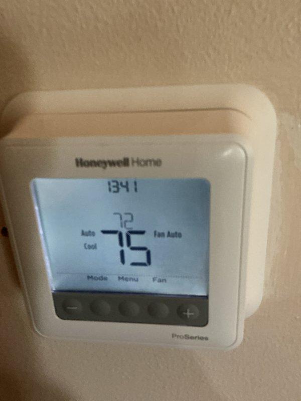 Completed scheduled HVAC maintenance on residential heating system. Verified Honeywell Home Pro-Series thermostat operation showing proper display function at 72°F ambient with setpoint of 75°F in auto cool mode with fan set to auto. Inspected basement mechanical equipment including water heater installation with proper venting and piping connections, confirming blue-handled isolation valve accessibility and adequate clearances around unit.