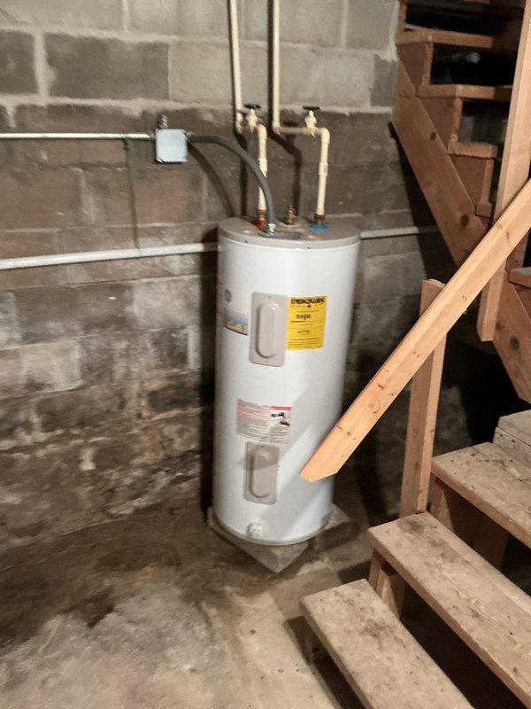 Completed scheduled HVAC maintenance on residential heating system. Verified Honeywell Home Pro-Series thermostat operation showing proper display function at 72°F ambient with setpoint of 75°F in auto cool mode with fan set to auto. Inspected basement mechanical equipment including water heater installation with proper venting and piping connections, confirming blue-handled isolation valve accessibility and adequate clearances around unit.