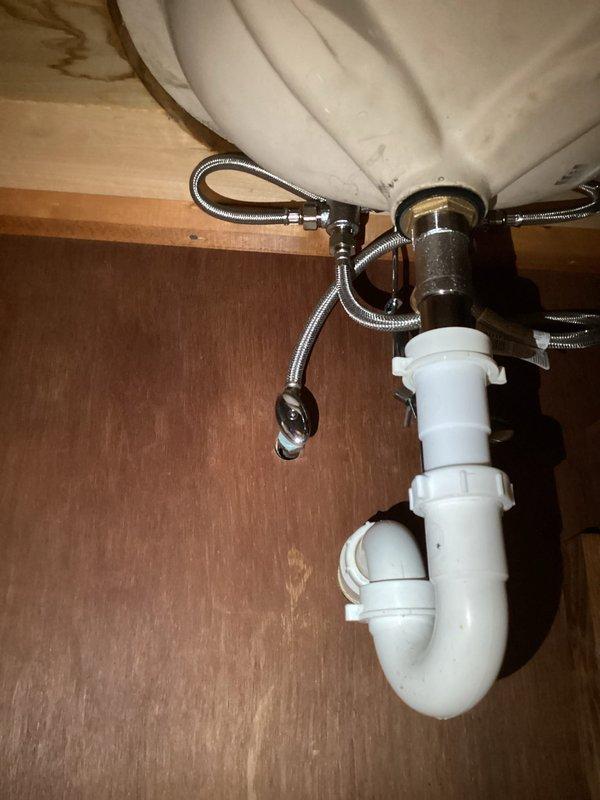 Replaced bathroom faucet assembly including chrome spout, dual acrylic knob handles with mounting plate, and aerator. Connected new flexible braided stainless steel supply lines to shutoff valves and verified proper water flow and drainage through existing P-trap assembly with no leaks detected.