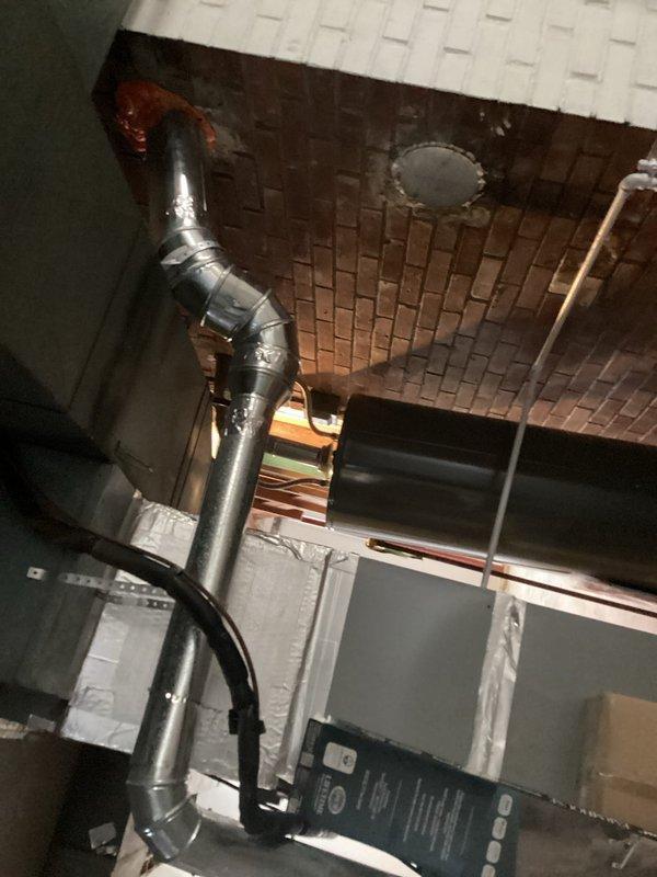 Responded to service call regarding moisture infiltration and condensation issues affecting interior brick chimney chase, with visible drywall damage and paint deterioration on adjacent walls. Performed comprehensive inspection of existing ceramic flue system serving both gas furnace and water heater venting through central brick chimney. Upon examination, identified compromised flue liners allowing combustion gases and moisture to penetrate into brick chase cavity, causing condensation accumulation and structural concerns. Documented existing metallic ductwork configuration and flue penetrations through masonry with photographic evidence. Assessed venting requirements for both appliances and evaluated chimney chase condition to determine appropriate remediation approach. Provided technical recommendations for flue replacement options, including metal liner systems suitable for dual-appliance venting applications, and outlined scope of work necessary to address moisture intrusion and r