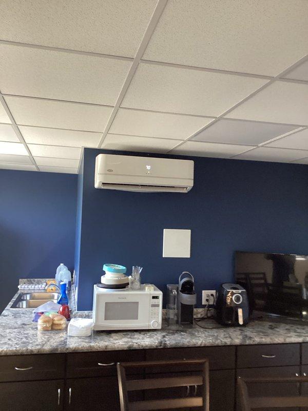 Responded to service call for leaking ductless mini-split system in commercial break room. Upon inspection, identified active water leak from wall-mounted Carrier air handler unit. Diagnosed condensate drainage issue causing water to escape from indoor unit rather than properly draining through condensate line.