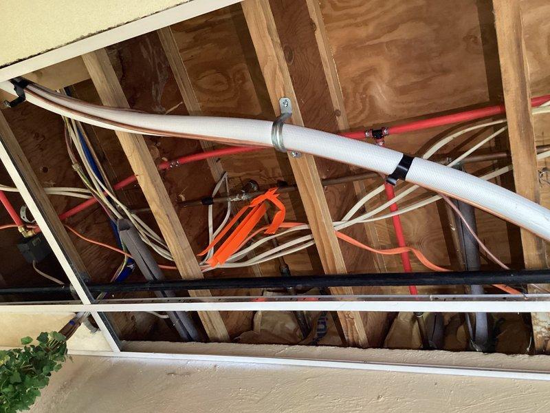 Responded to water leak between washing machine connection and outdoor spigot. Accessed attic space to inspect plumbing infrastructure and identified leak source at connection point. Previously assisted with emergency water shut-off to prevent damage while property was unoccupied. Completed repairs to resolve ongoing leak issue, inspected copper and PEX water lines, verified all connections secure, and restored water service.