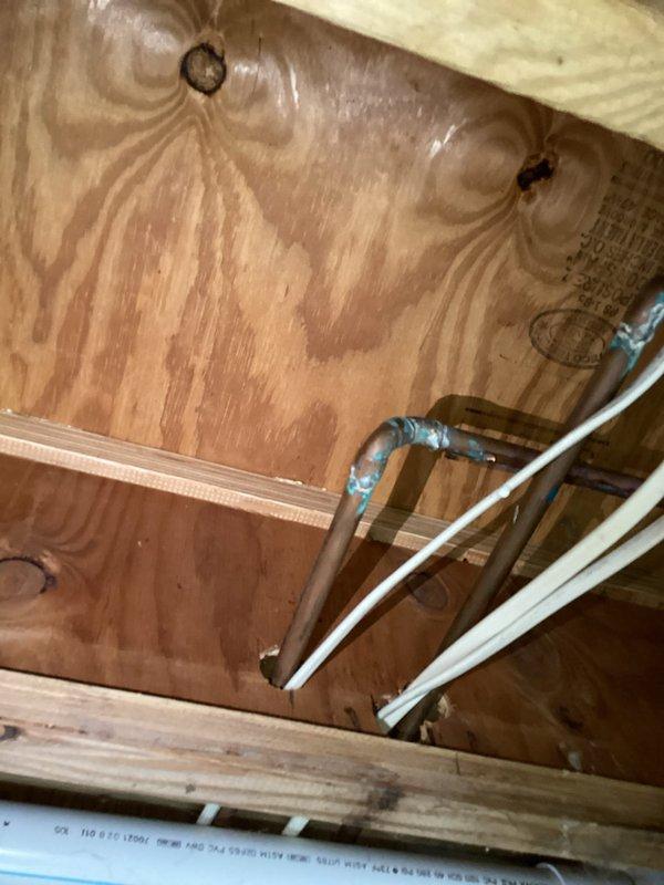 Responded to water leak between washing machine connection and outdoor spigot. Accessed attic space to inspect plumbing infrastructure and identified leak source at connection point. Previously assisted with emergency water shut-off to prevent damage while property was unoccupied. Completed repairs to resolve ongoing leak issue, inspected copper and PEX water lines, verified all connections secure, and restored water service.