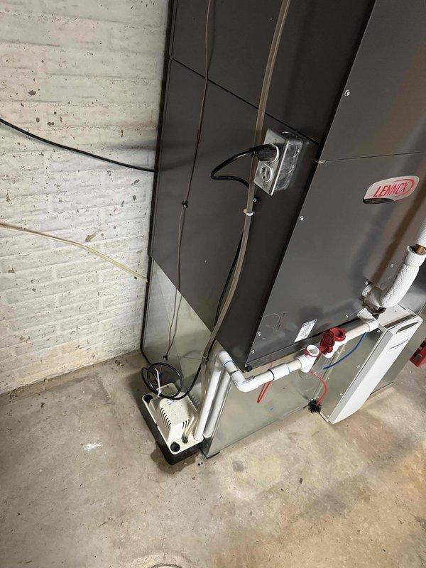 Replaced existing zoning system and installed new Lennox air handler unit in basement utility area. Configured extensive flexible ductwork network with reflective insulation to distribute conditioned air to multiple zones throughout the residence. Installed PVC condensate drain lines with shutoff valves, condensate pump with electrical connections, and refrigerant line set. Mounted control module and completed all electrical wiring including thermostat control cables and power supply connections to ensure proper zone control operation.