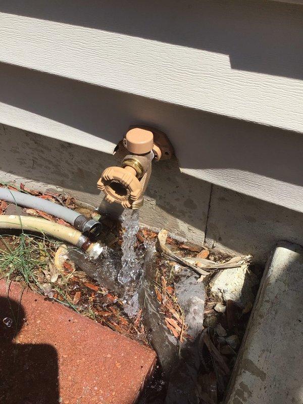 Responded to water leak at main plumbing entry point beneath concrete foundation. Performed demolition work to expose copper supply line running vertically through concrete substrate, revealing leak at underground connection point. Removed concrete flooring and wall material to access compromised piping with threaded fittings. Assessed two exterior hose bibs mounted in concrete foundation showing signs of deterioration, water staining, and potential failure requiring replacement to prevent continued water intrusion and foundation damage.