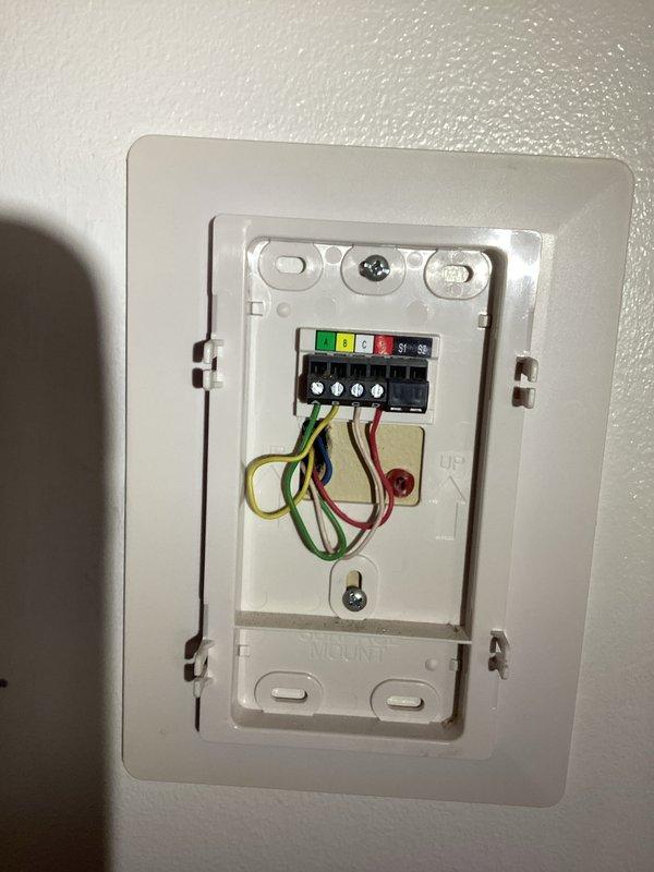 Returned to property with prepaid thermostat replacement unit and completed installation. Removed existing wall-mounted thermostat, disconnected all wiring from terminal block, and properly installed new control unit with all wire connections verified and secured to appropriate terminals including power, heating, cooling, and ground conductors. Tested system operation to confirm proper thermostat function and communication with HVAC equipment.