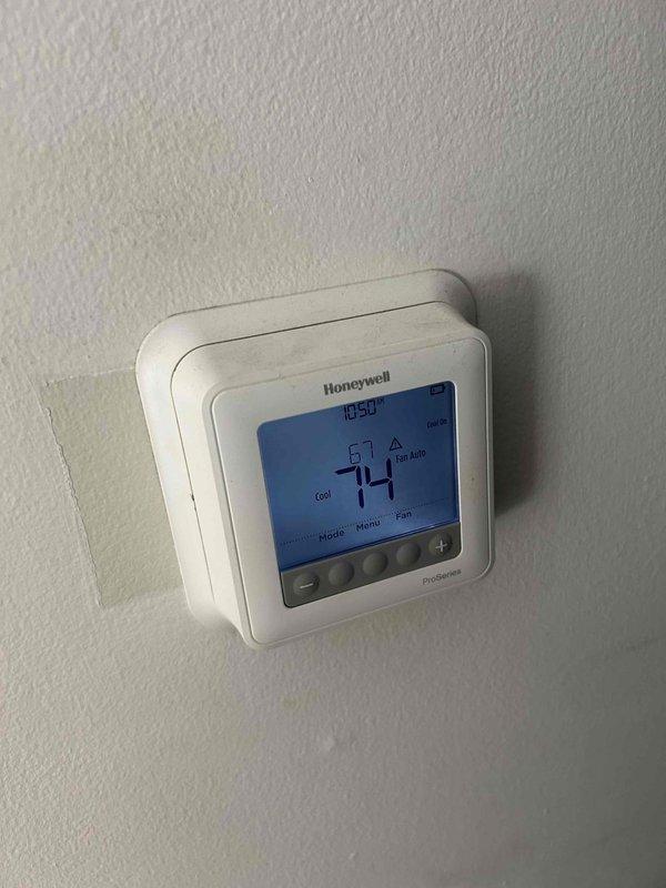Responded to service call for outdoor condensing unit producing loud intermittent noise every two minutes. Inspected electrical components and capacitor connections, finding signs of age and environmental exposure on wiring and capacitor assembly. Verified thermostat operation and system cycling behavior, documented internal component condition with capacitor showing dirt accumulation and multiple wire connections intact.