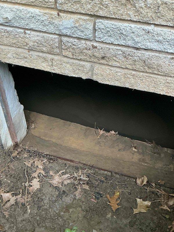 Responded to emergency service call for failed sump pump with significant water accumulation in crawl space. Upon arrival, found 5-6 inches of standing water throughout the crawl space area, accessed through foundation opening. Performed maintenance procedures to address the pump failure and assessed the extent of water infiltration. Documented conditions of crawl space access point and surrounding foundation area, noting debris accumulation at exterior opening that may impact drainage patterns around the structure.