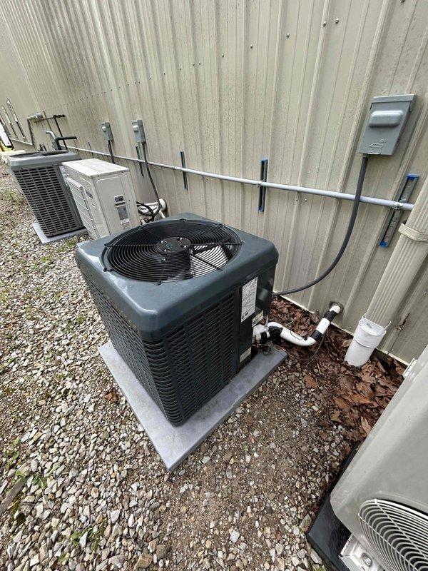 Responded to callback for AC system blowing warm air with no cooling capability. Inspected outdoor condenser units and verified electrical connections, refrigerant line sets, and disconnect boxes. Documented existing equipment condition including weathered line insulation and debris accumulation around units requiring attention for proper airflow and system performance.