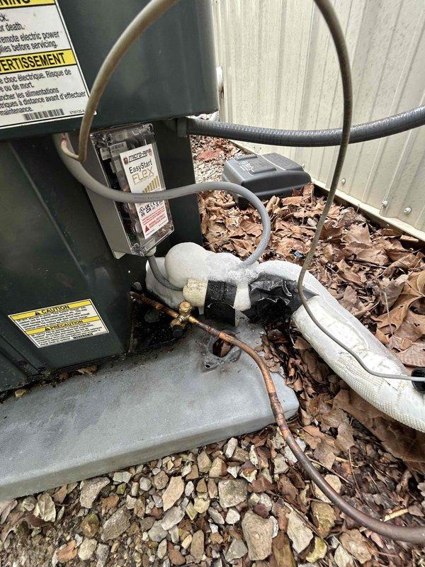 Responded to callback for AC system blowing warm air with no cooling capability. Inspected outdoor condenser units and verified electrical connections, refrigerant line sets, and disconnect boxes. Documented existing equipment condition including weathered line insulation and debris accumulation around units requiring attention for proper airflow and system performance.