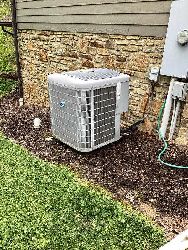 Completed basic monthly cooling maintenance visit on residential HVAC system. Inspected Carrier outdoor condensing unit and verified thermostat operation showing proper temperature control set to auto mode with cooling setpoint at 80°F and heating at 60°F. Performed routine system inspection, confirmed unit operational status, and documented equipment condition through photographic records of both indoor controls and outdoor equipment.