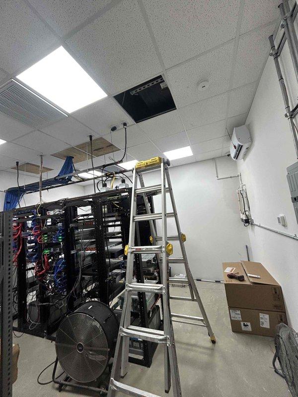 Responded to callback for commercial AC system blowing warm air with no cooling. Upon arrival, found R-410A system with frozen evaporator coil as indicated by suction temperature of 27.5°F and negative superheat reading of -0.4°F. Diagnosed airflow restriction causing coil freeze-up in telecommunications equipment room. Allowed system to thaw completely, verified proper refrigerant pressures with suction at 93.1 PSIG and liquid line at 187.6 PSIG, and confirmed subcooling at 22.6°F within acceptable range, restoring normal cooling operation.