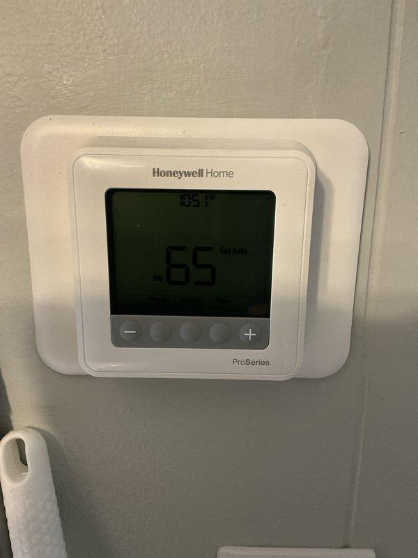Completed basic monthly HVAC maintenance including cooling coil check and condenser coil check on residential air handler system. Observed heavily soiled air filter with significant dust and debris accumulation requiring replacement, though filter size specifications were not documented. Verified thermostat operation showing proper display function at 65°F setpoint with fan in auto mode.