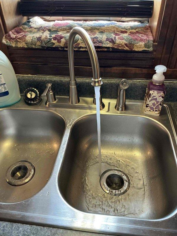 Responded to service call for copper pipe replacement and shut off valve installation under kitchen sink. Upon arrival, assessed the existing plumbing configuration beneath a stainless steel double-basin sink with modern pull-down sprayer faucet. Removed deteriorated copper supply line and installed new copper piping with proper connections to the existing water supply system. Installed new shut off valve under sink to provide convenient water control for future maintenance needs. Tested all connections for leaks, verified proper water flow and pressure to faucet, and confirmed shut off valve operates correctly. Left work area clean with all plumbing components functioning properly and no active leaks detected.