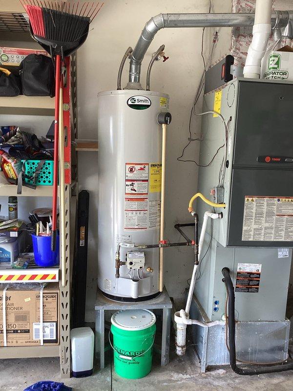 Responded to no-water service call and diagnosed inoperative A.O. Smith gas water heater in residential garage utility area. Upon inspection, determined water heater had failed and required replacement to restore hot water service to the residence. Documented existing installation configuration including gas line connections, water supply lines with shutoff valve, and exhaust venting adjacent to HVAC furnace unit for service records.