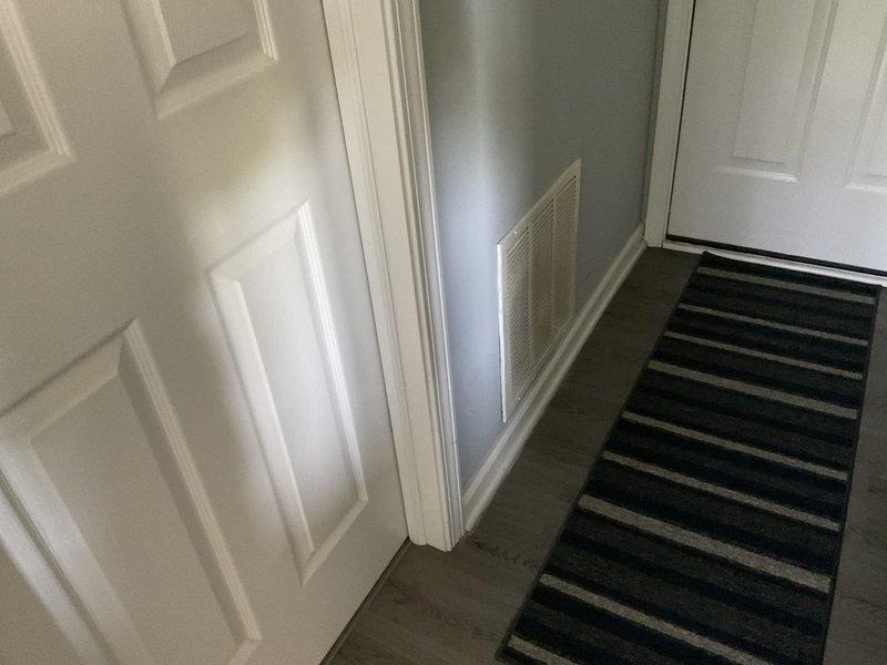 Conducted on-site assessment for duct cleaning estimate at residential property. Inspected accessible HVAC ductwork system including floor-level return air grille in entryway area and wall-mounted supply vent above interior doorway. Documented current condition of ventilation components and duct access points to determine scope of cleaning services required.
