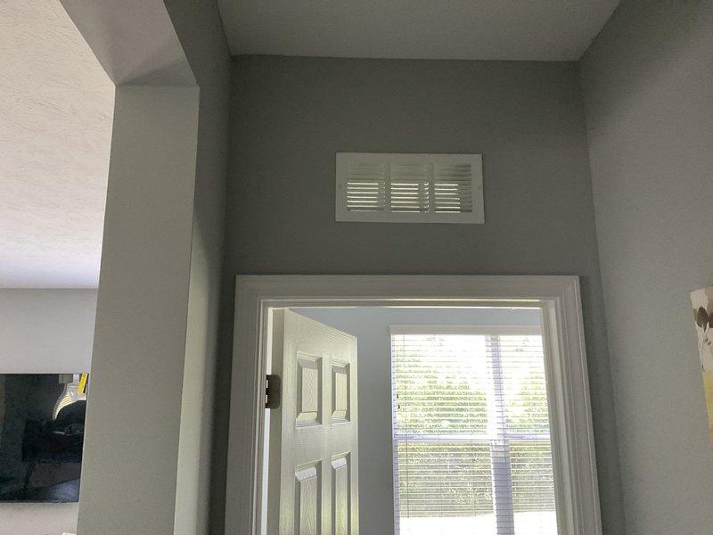 Conducted on-site assessment for duct cleaning estimate at residential property. Inspected accessible HVAC ductwork system including floor-level return air grille in entryway area and wall-mounted supply vent above interior doorway. Documented current condition of ventilation components and duct access points to determine scope of cleaning services required.