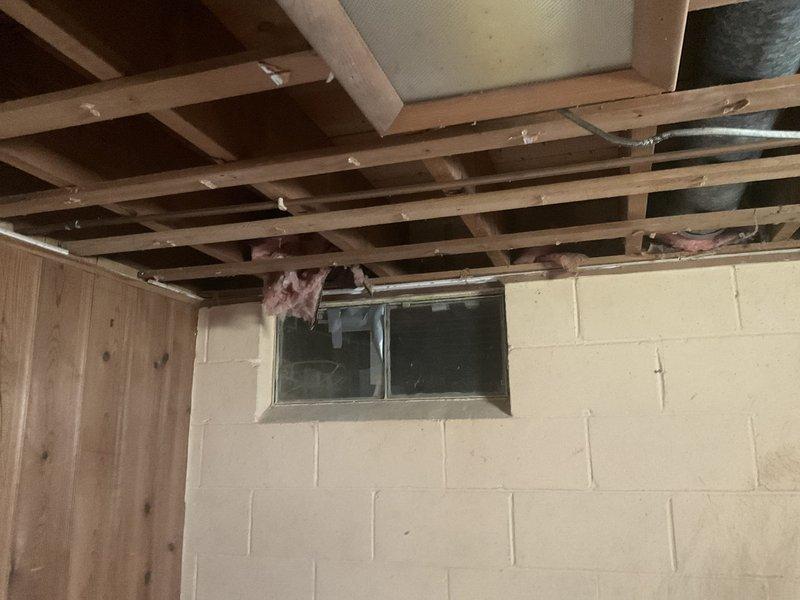 Conducted site assessment of unfinished basement area to evaluate feasibility of extending ductwork to back room. Inspected existing HVAC distribution system, including current metal ductwork running along ceiling joists. Evaluated structural layout, including exposed floor joists, concrete block foundation walls, and available routing pathways for new duct installation. Documented ceiling cavity space, clearances around existing utilities, and potential connection points to main trunk line. Photographed current conditions to support estimate preparation for ductwork extension project.
