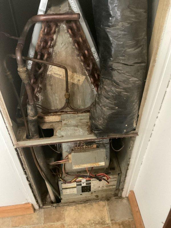 Conducted comprehensive assessment of existing HVAC system following customer report of low refrigerant levels. Upon inspection, identified severely corroded copper refrigerant lines with extensive brownish-red oxidation and deterioration throughout the line set. System exhibited significant age-related wear with compromised refrigerant piping integrity. Documented equipment condition through photographic evidence showing degraded copper lines, air handler unit, and overall system installation within interior closet space. Prepared full system replacement estimate per customer request for expedited timeline, as continued operation with deteriorated refrigerant lines presents risk of system failure and inefficiency.